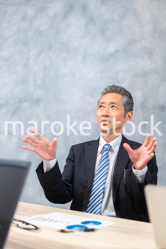 スーツで意見を述べる経営者