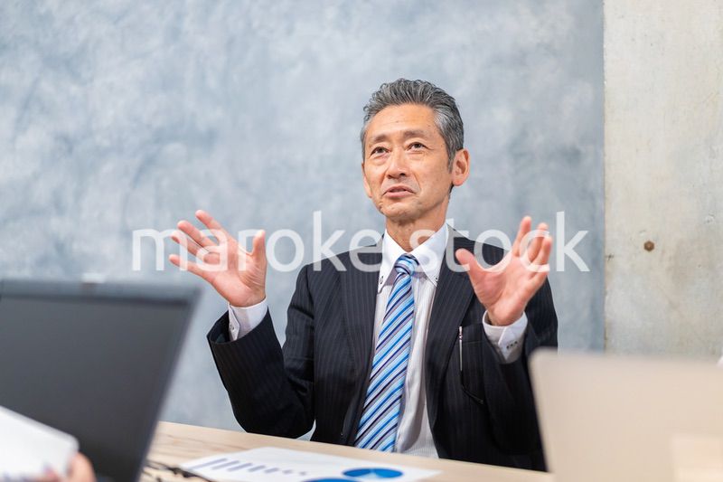 スーツで意見を述べる経営者