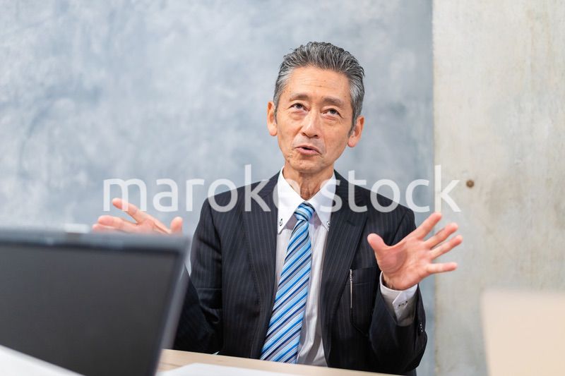 スーツで意見を述べる経営者