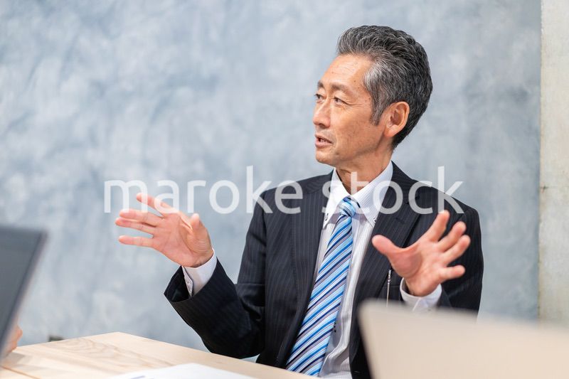 スーツで意見を述べる経営者
