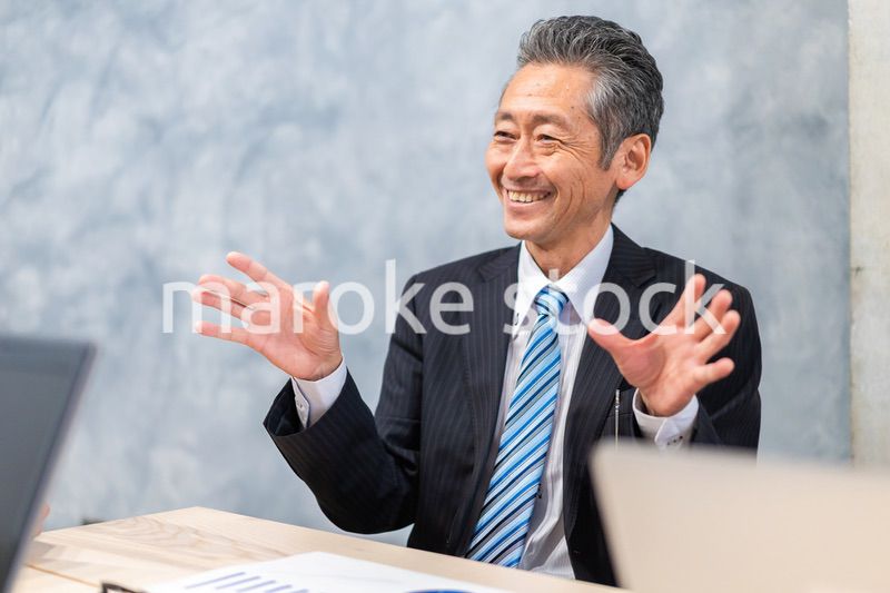 スーツで意見を述べる経営者