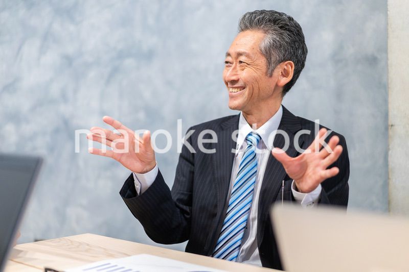 スーツで意見を述べる経営者