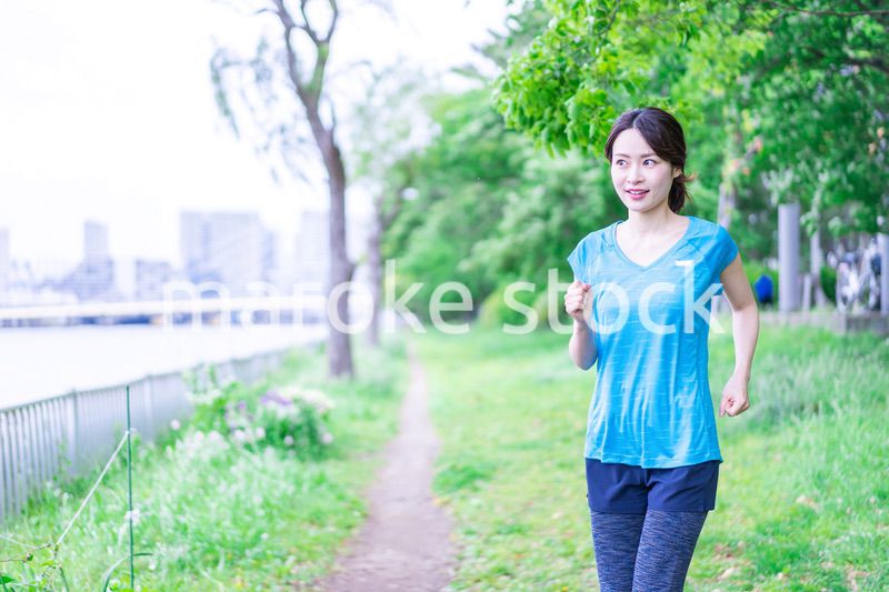 自然の中でランニングをする若い女性