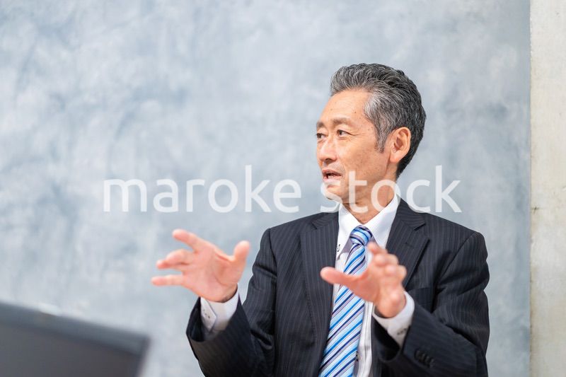 スーツで意見を述べる経営者