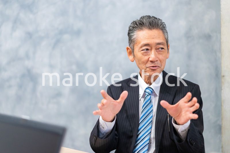 スーツで意見を述べる経営者