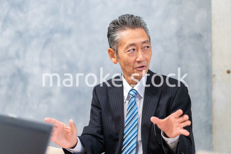 スーツで意見を述べる経営者