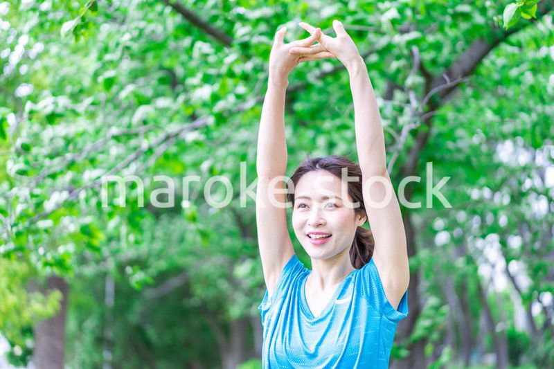 自然の中でストレッチをする若い女性