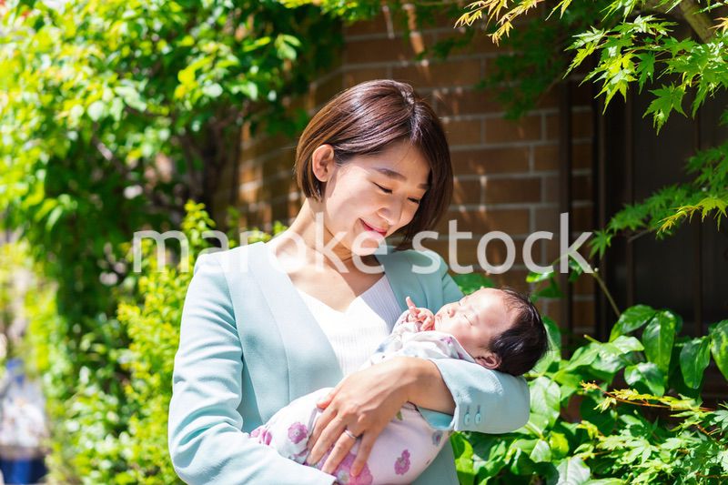 赤ちゃんを抱きしめるキャリアウーマン