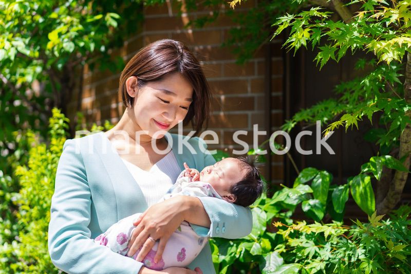 赤ちゃんを抱きしめるキャリアウーマン