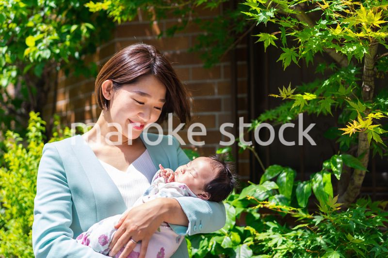 赤ちゃんを抱きしめるキャリアウーマン
