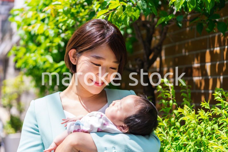 赤ちゃんを抱きしめるキャリアウーマン