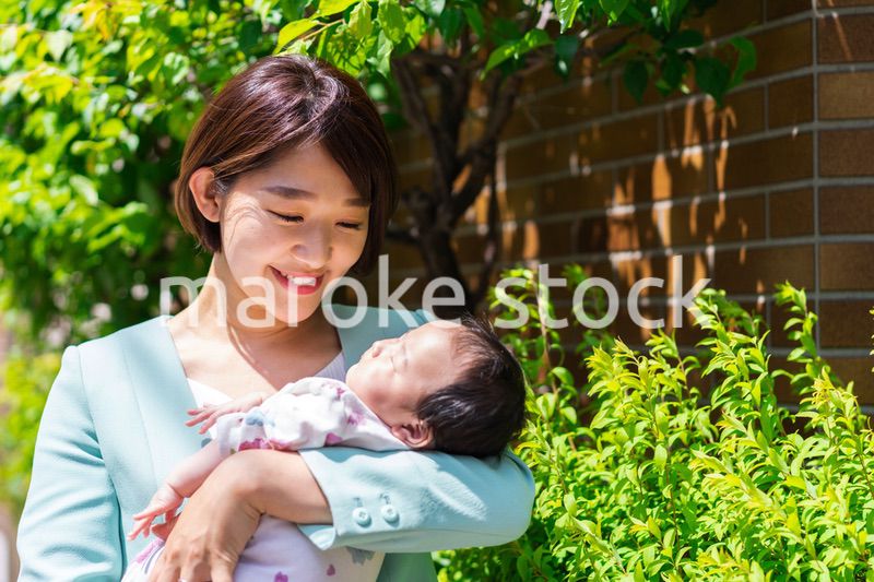 赤ちゃんを抱きしめるキャリアウーマン