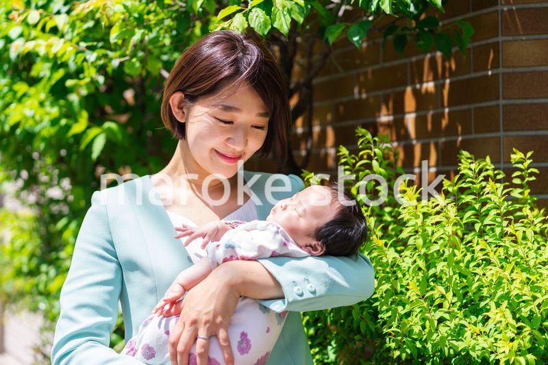 赤ちゃんを抱きしめるキャリアウーマン