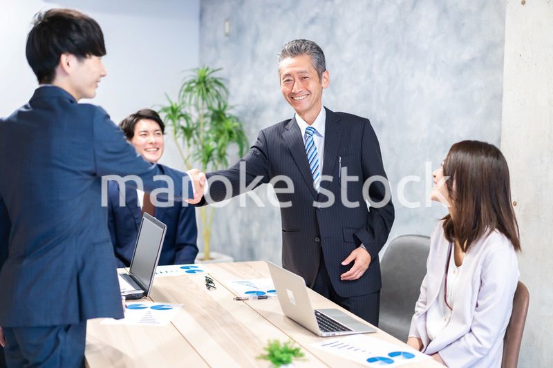笑顔で握手をするビジネスパーソン