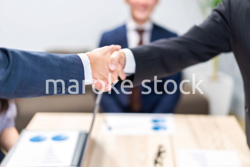 笑顔で握手をするビジネスパーソン