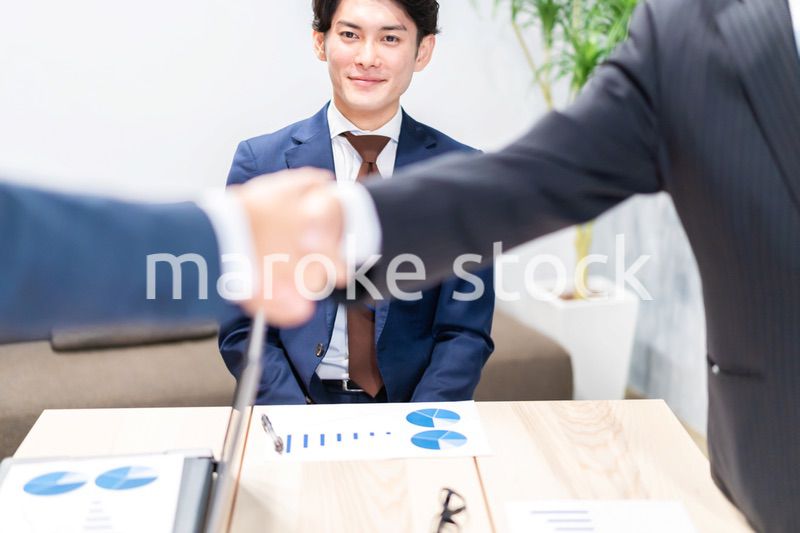 笑顔で握手をするビジネスパーソン