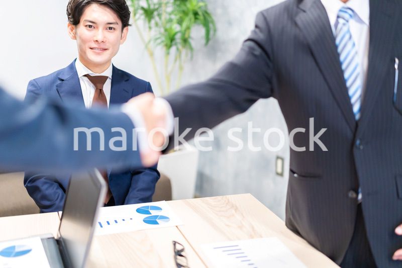 笑顔で握手をするビジネスパーソン