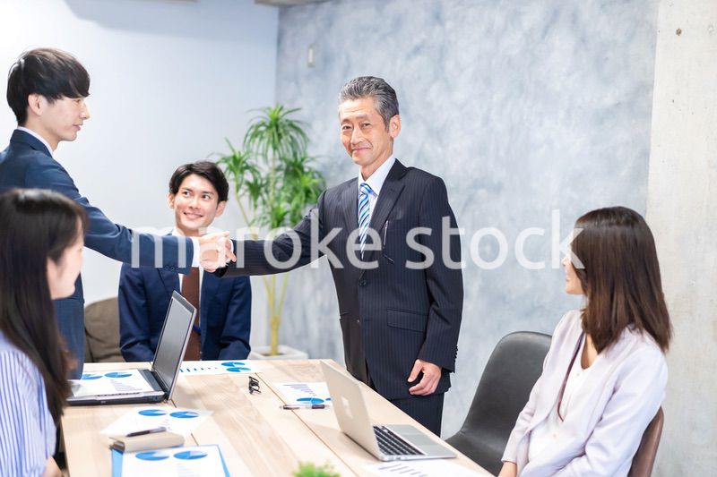 笑顔で握手をするビジネスパーソン