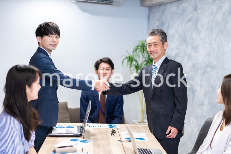 笑顔で握手をするビジネスパーソン