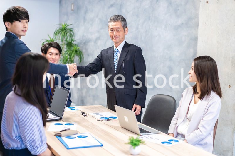 笑顔で握手をするビジネスパーソン