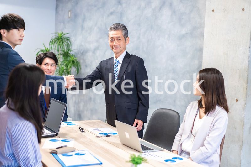 笑顔で握手をするビジネスパーソン