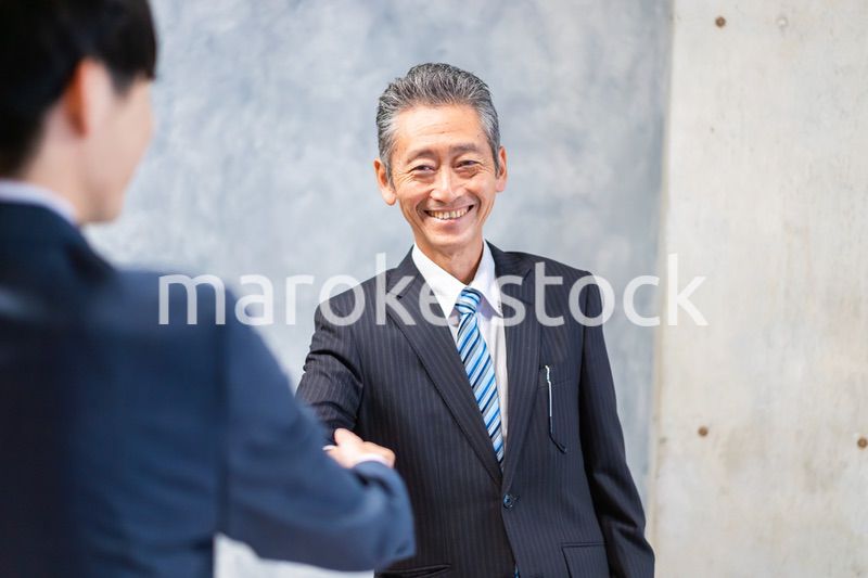 笑顔で握手をするビジネスパーソン