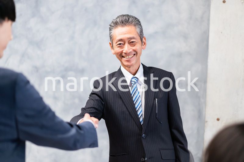 笑顔で握手をするビジネスパーソン