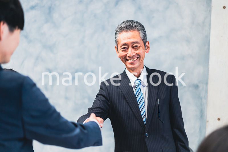 笑顔で握手をするビジネスパーソン