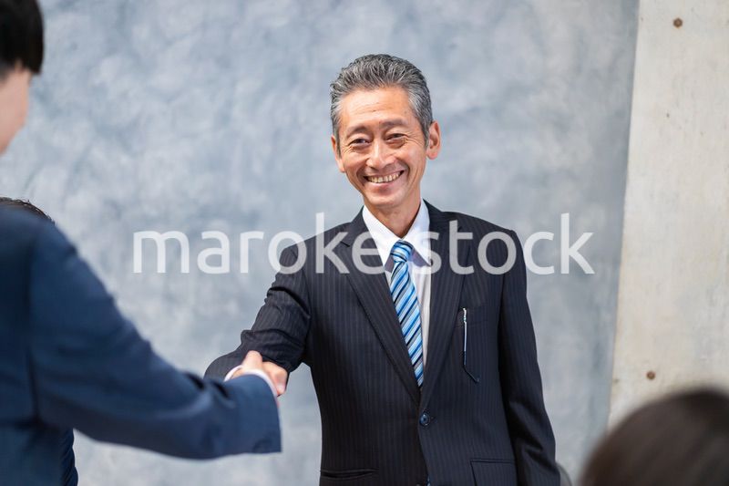 笑顔で握手をするビジネスパーソン