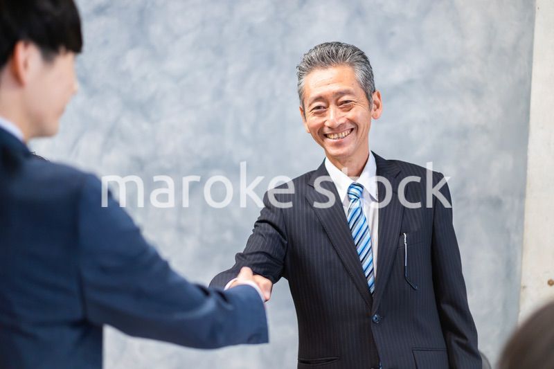 笑顔で握手をするビジネスパーソン
