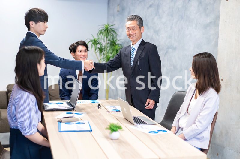 笑顔で握手をするビジネスパーソン