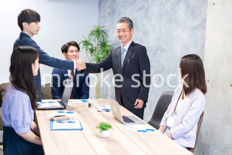 笑顔で握手をするビジネスパーソン