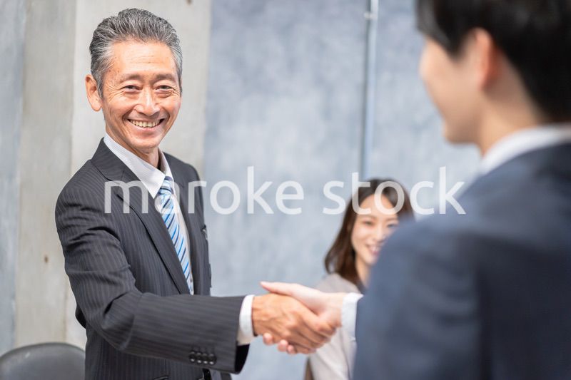 笑顔で握手をするビジネスパーソン