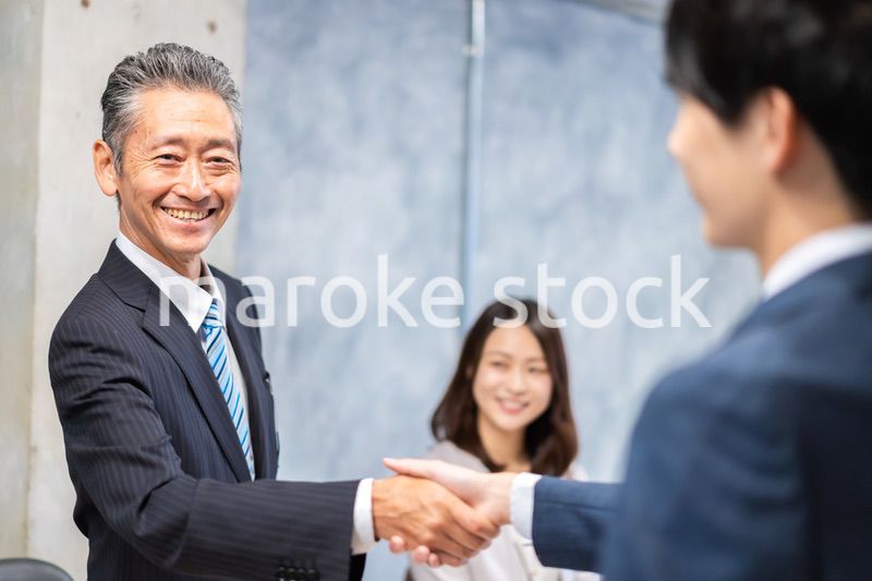 笑顔で握手をするビジネスパーソン