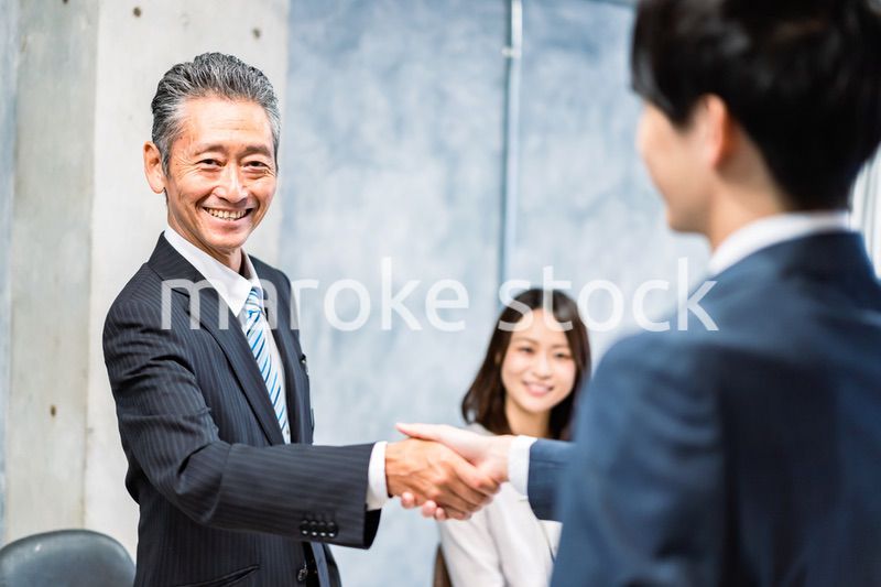笑顔で握手をするビジネスパーソン