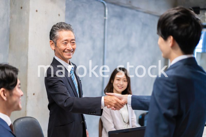 笑顔で握手をするビジネスパーソン