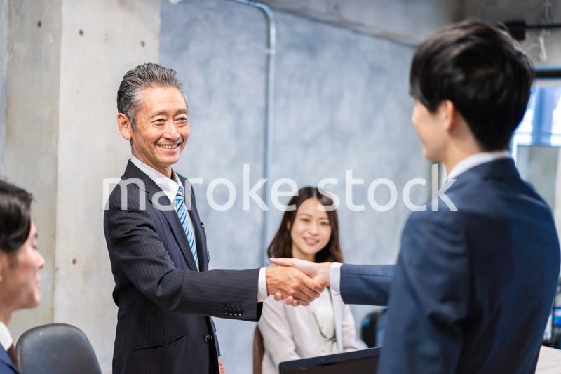 笑顔で握手をするビジネスパーソン