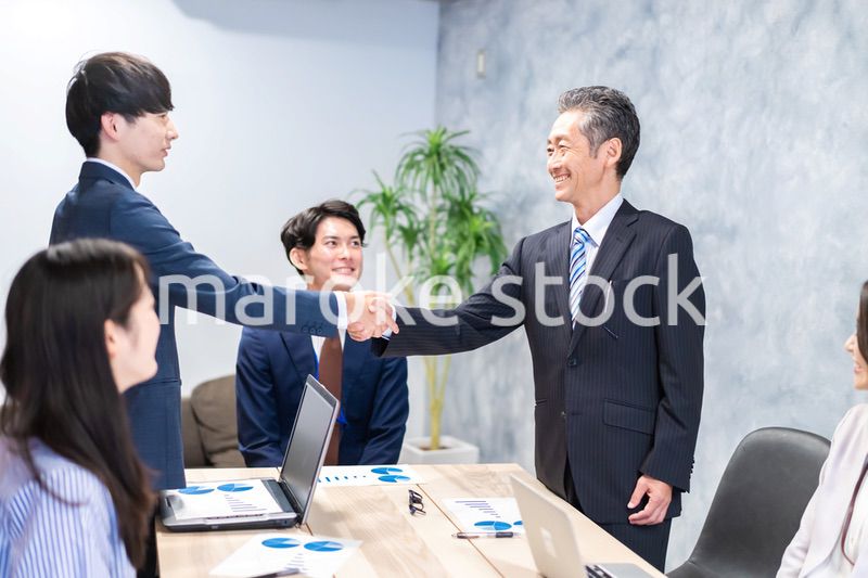 笑顔で握手をするビジネスパーソン