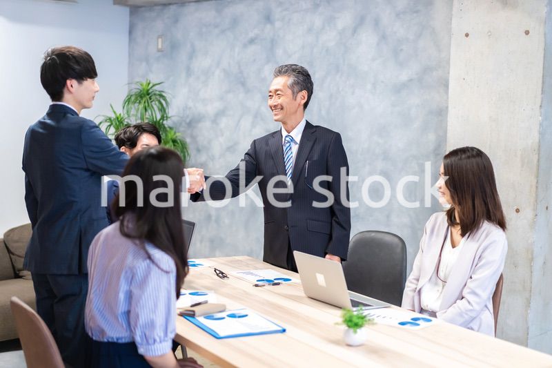 笑顔で握手をするビジネスパーソン