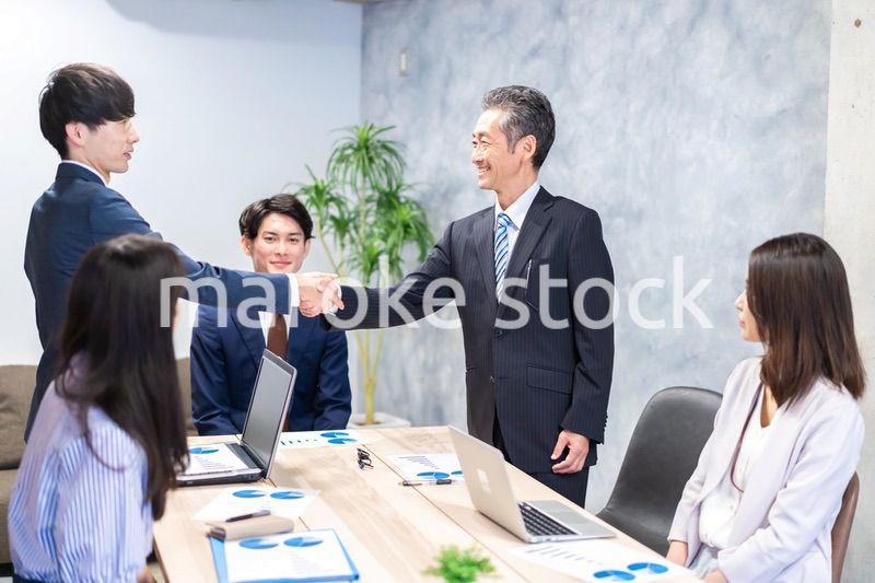笑顔で握手をするビジネスパーソン