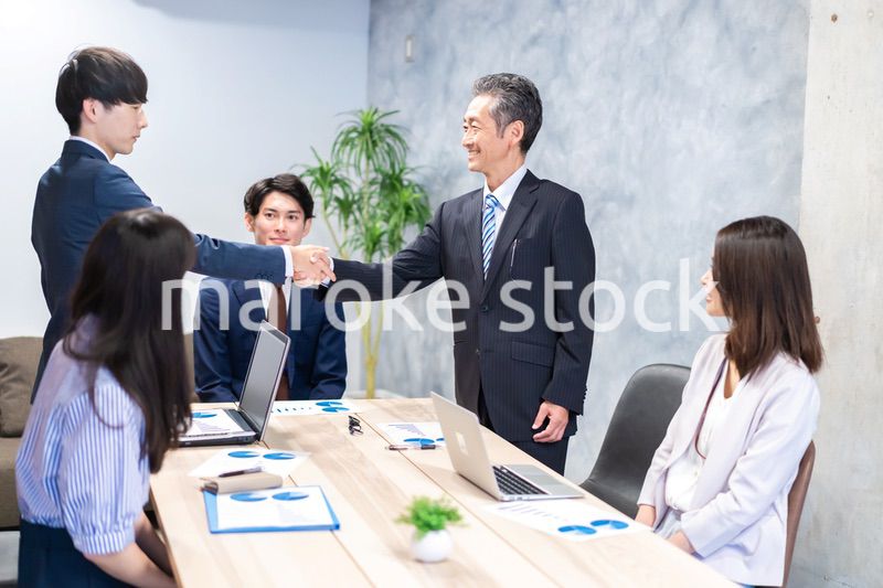 笑顔で握手をするビジネスパーソン