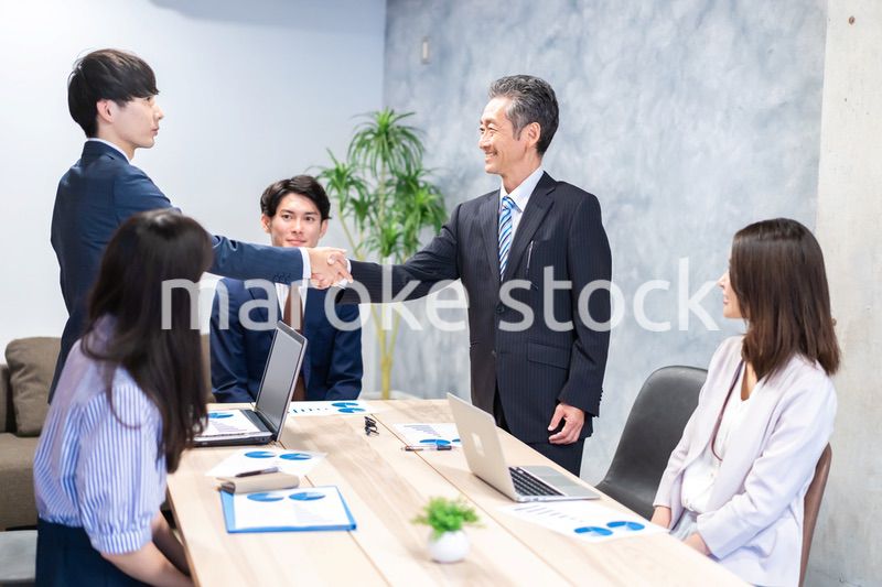 笑顔で握手をするビジネスパーソン