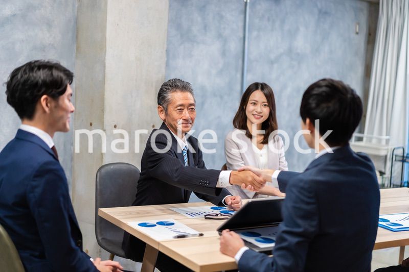笑顔で握手をするビジネスパーソン