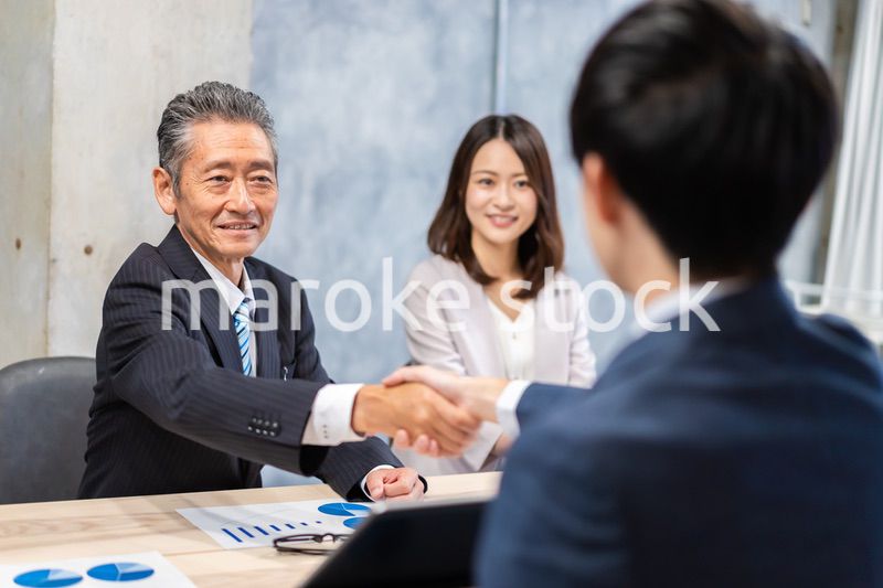 笑顔で握手をするビジネスパーソン