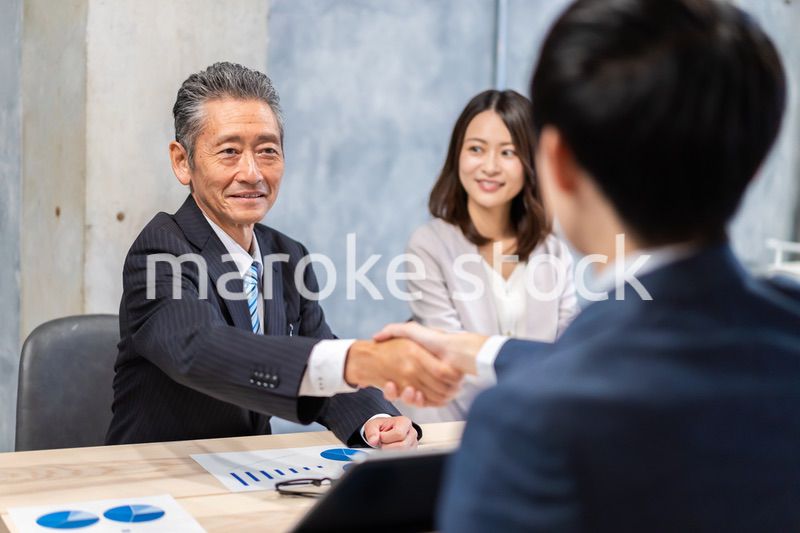 笑顔で握手をするビジネスパーソン