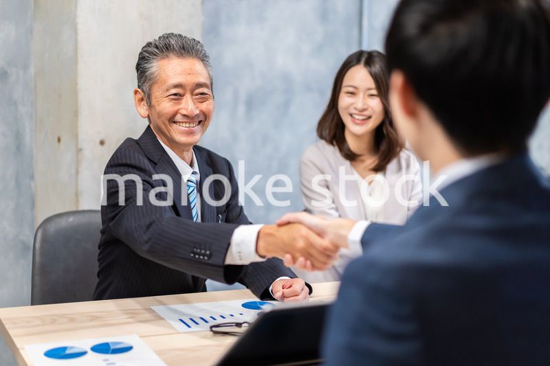 笑顔で握手をするビジネスパーソン