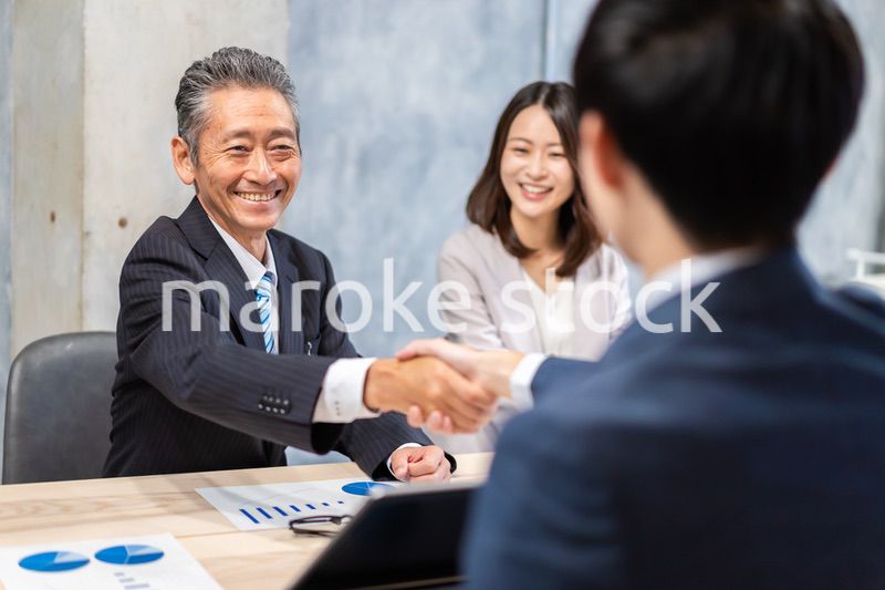 笑顔で握手をするビジネスパーソン