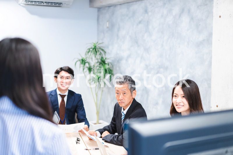 商品企画のプレゼンテーションを聞くビジネスパーソン