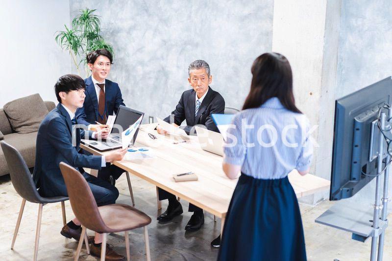 商品企画のプレゼンテーションを聞くビジネスパーソン