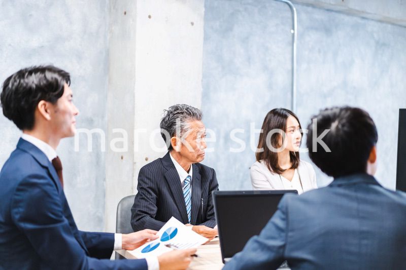 商品企画のプレゼンテーションを聞くビジネスパーソン